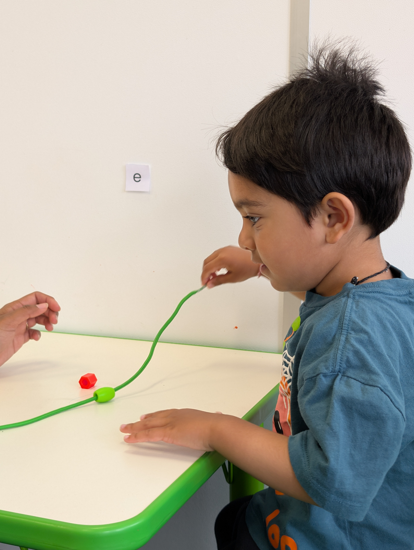 Child threading beads for fine motor skills