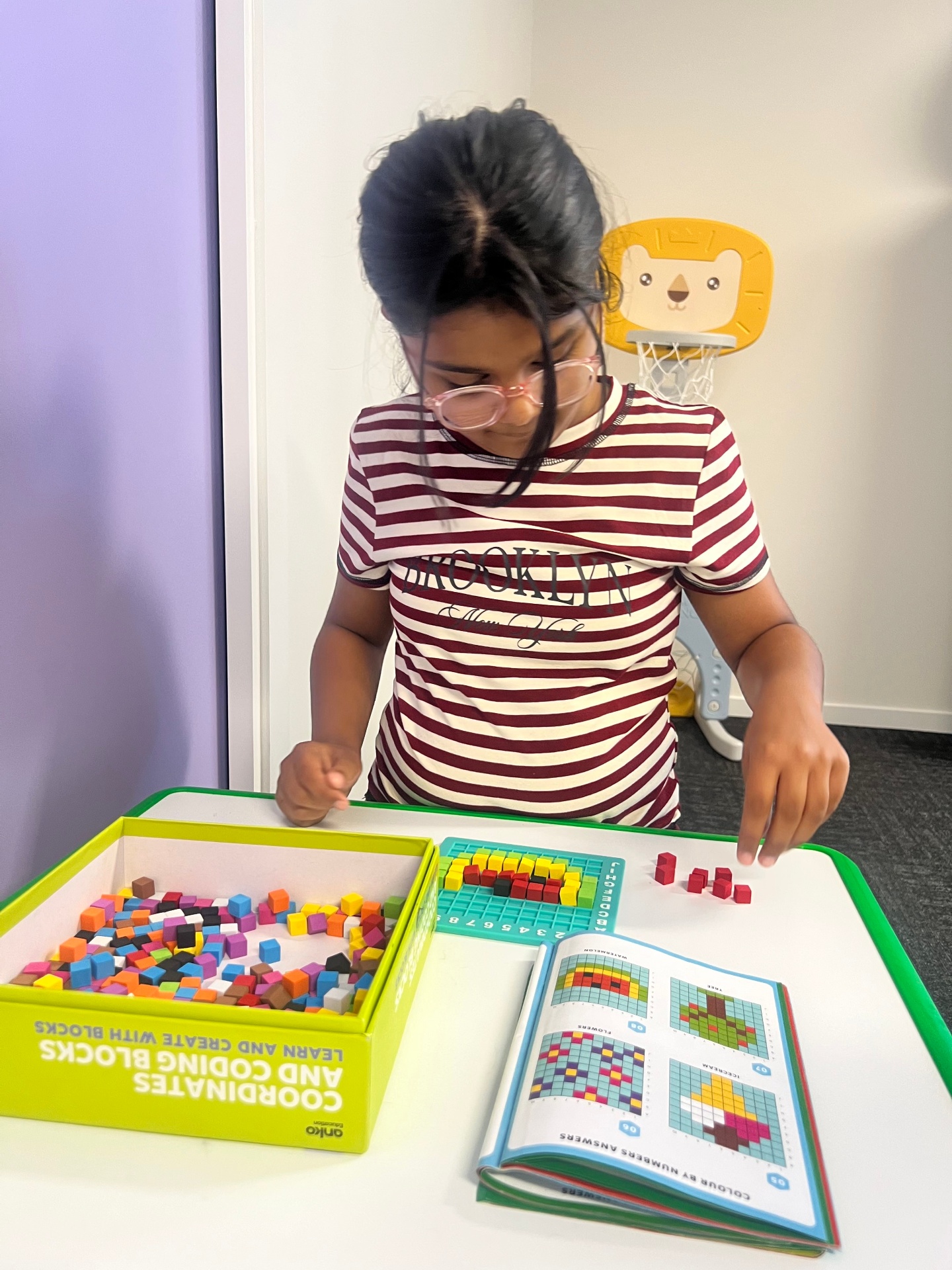 Child engaged in learning with colorful coding blocks
