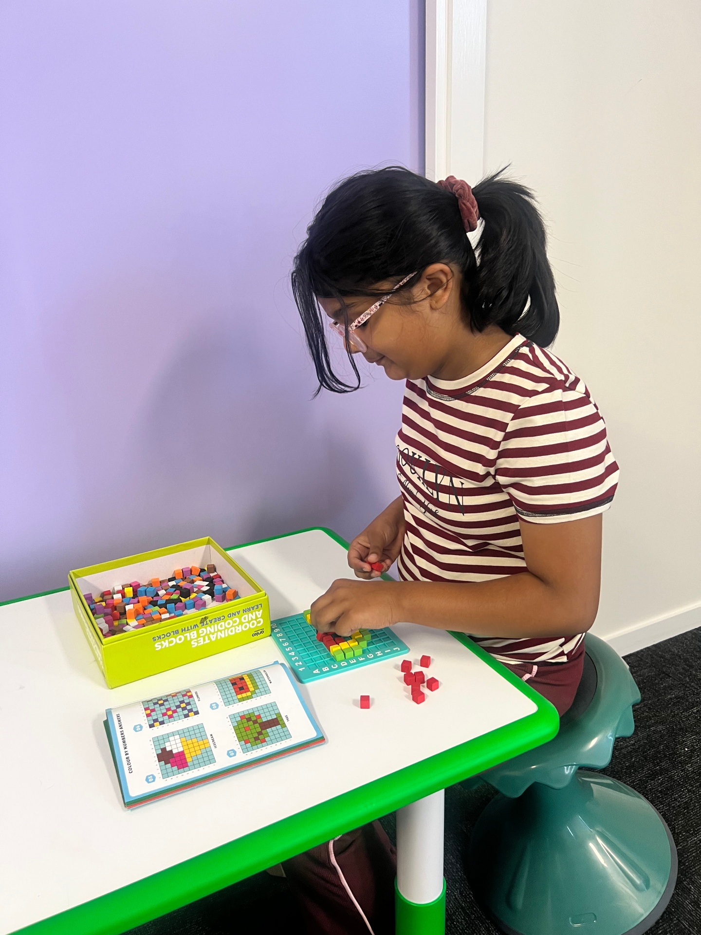 Side view of child focusing on block arrangement task