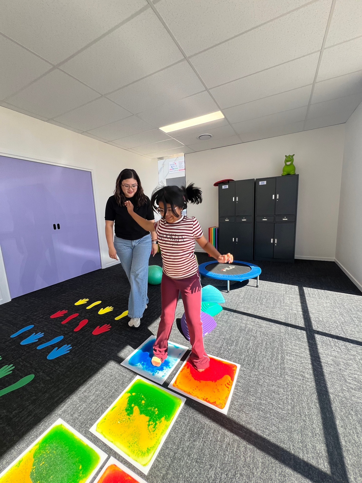 Jumping between colourful sensory floor tiles