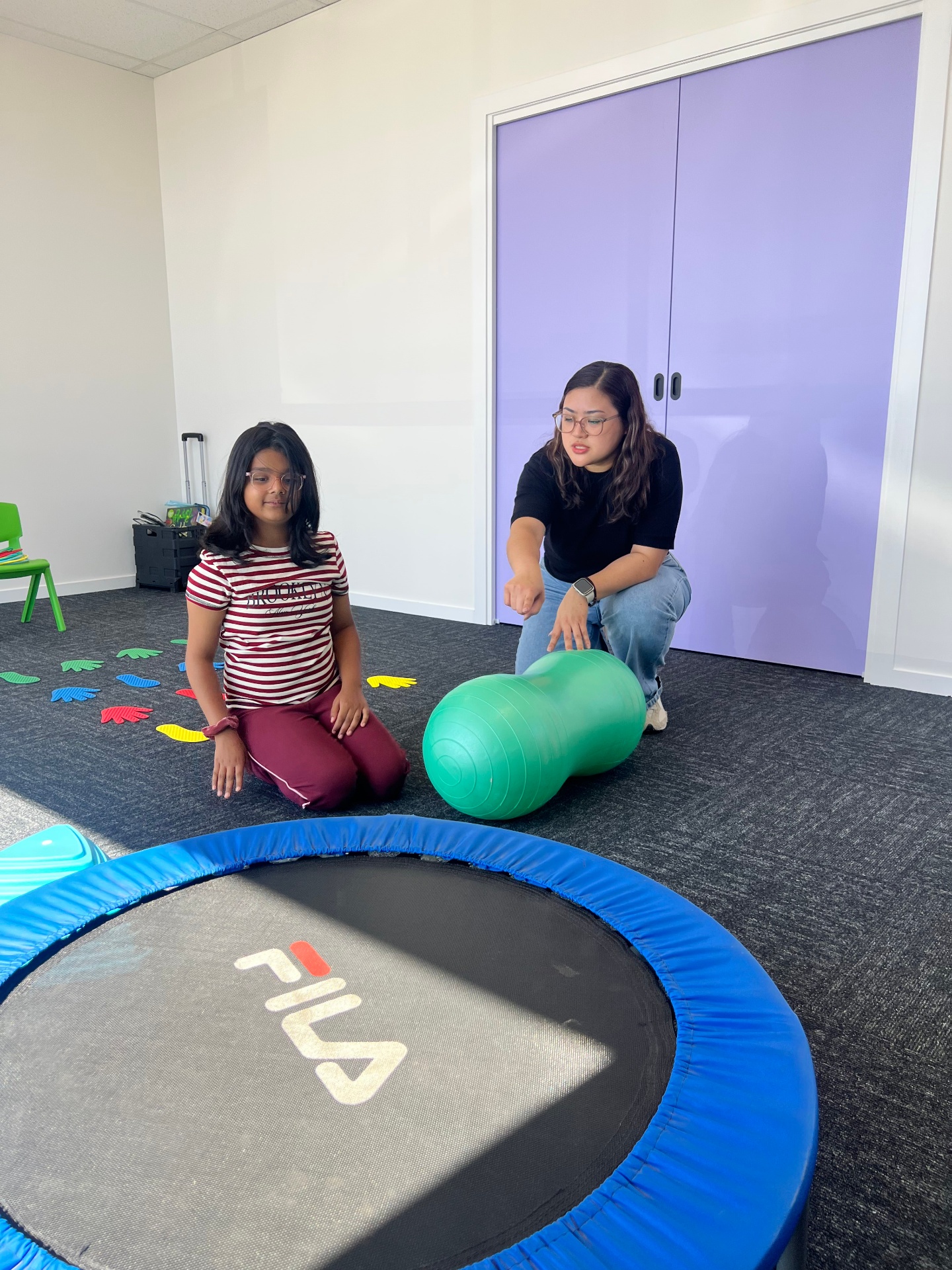 Therapist and child with mini trampoline