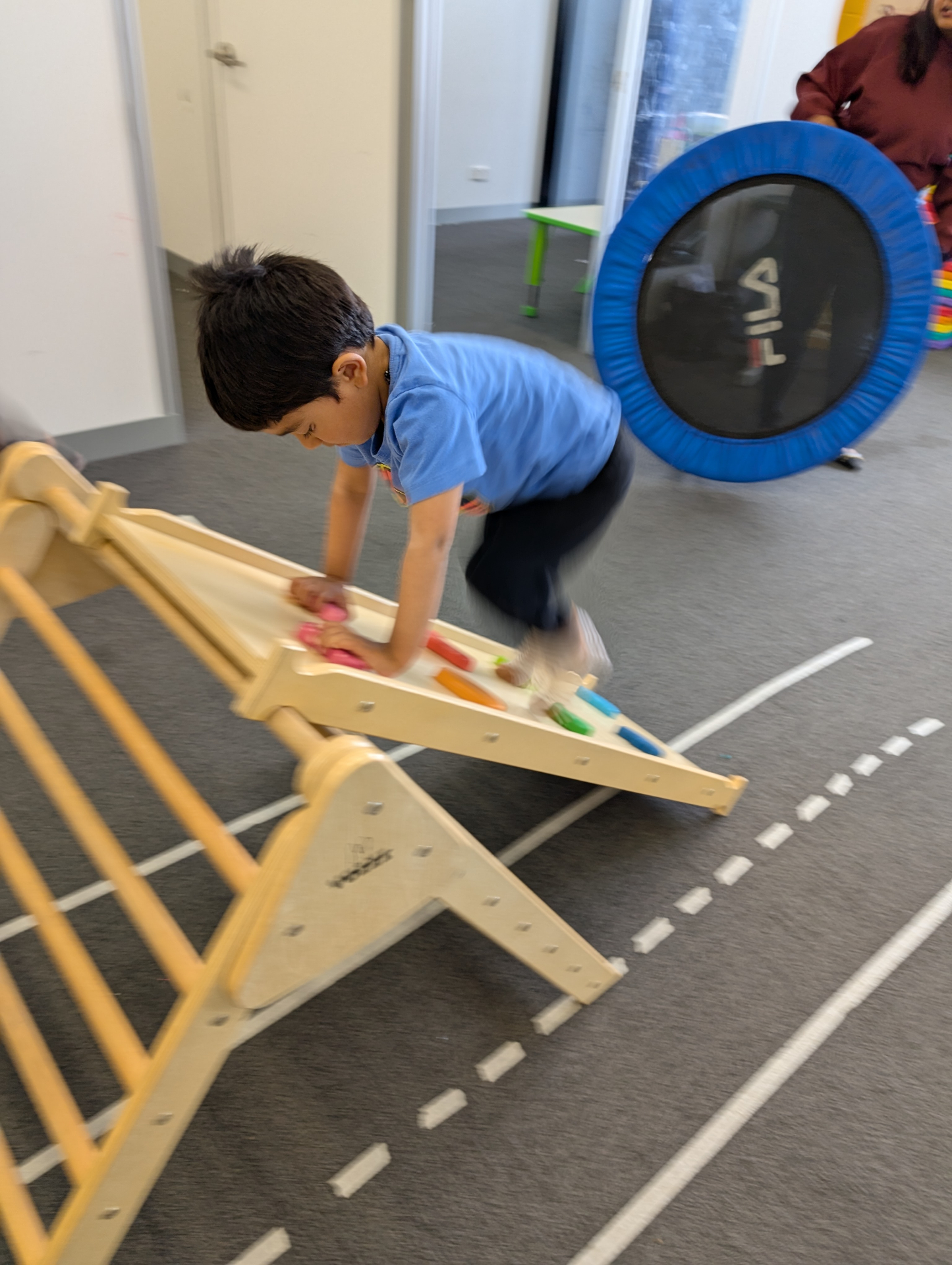 Child climbing wooden ramp